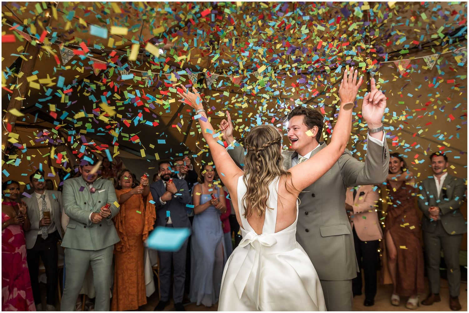 Bride and groom celebrate first dance with a colourful confetti canon in the marquee venue.