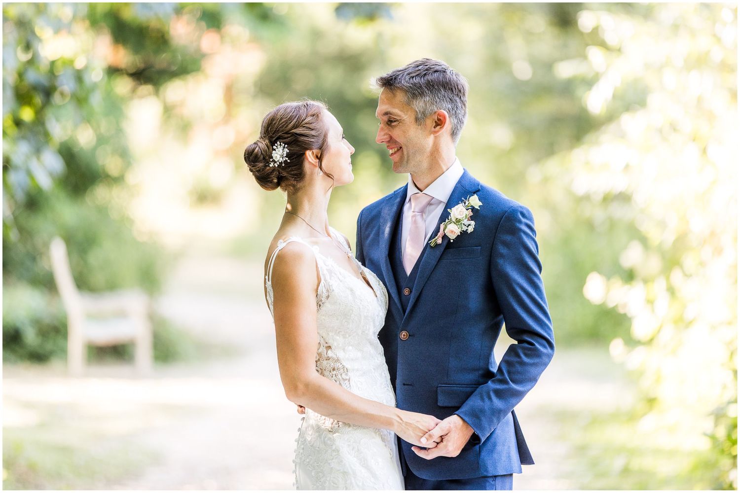 Bride and groom share a romantic moment in the lakeside woodland at Walhampton School near Lymington