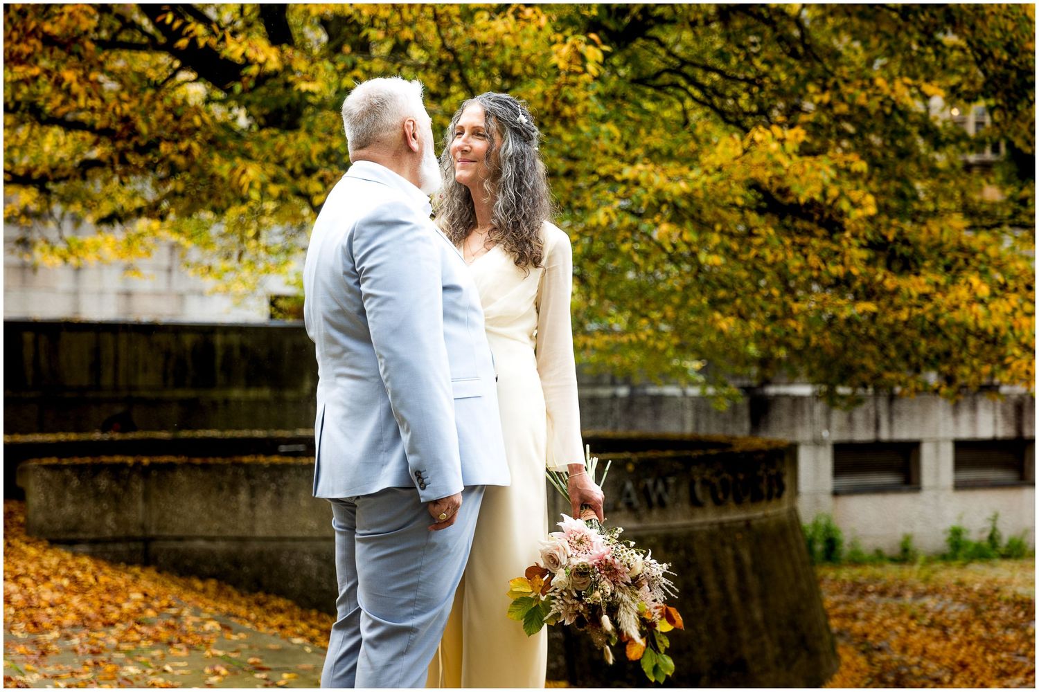 Autumn colour as the background to a couple wedding portrait photograph in Winchester