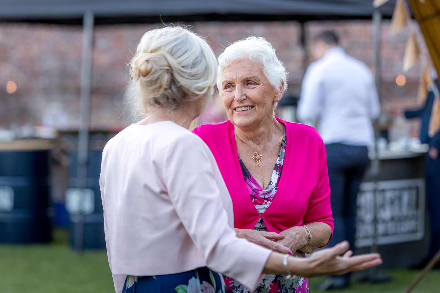 Wedding guests enjoying conversation and festivities at an outdoor reception.