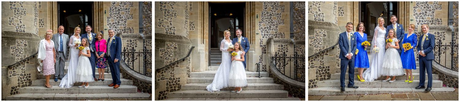 Wedding party members pose on the steps of a grand stone church entrance with Gothic architectural details.