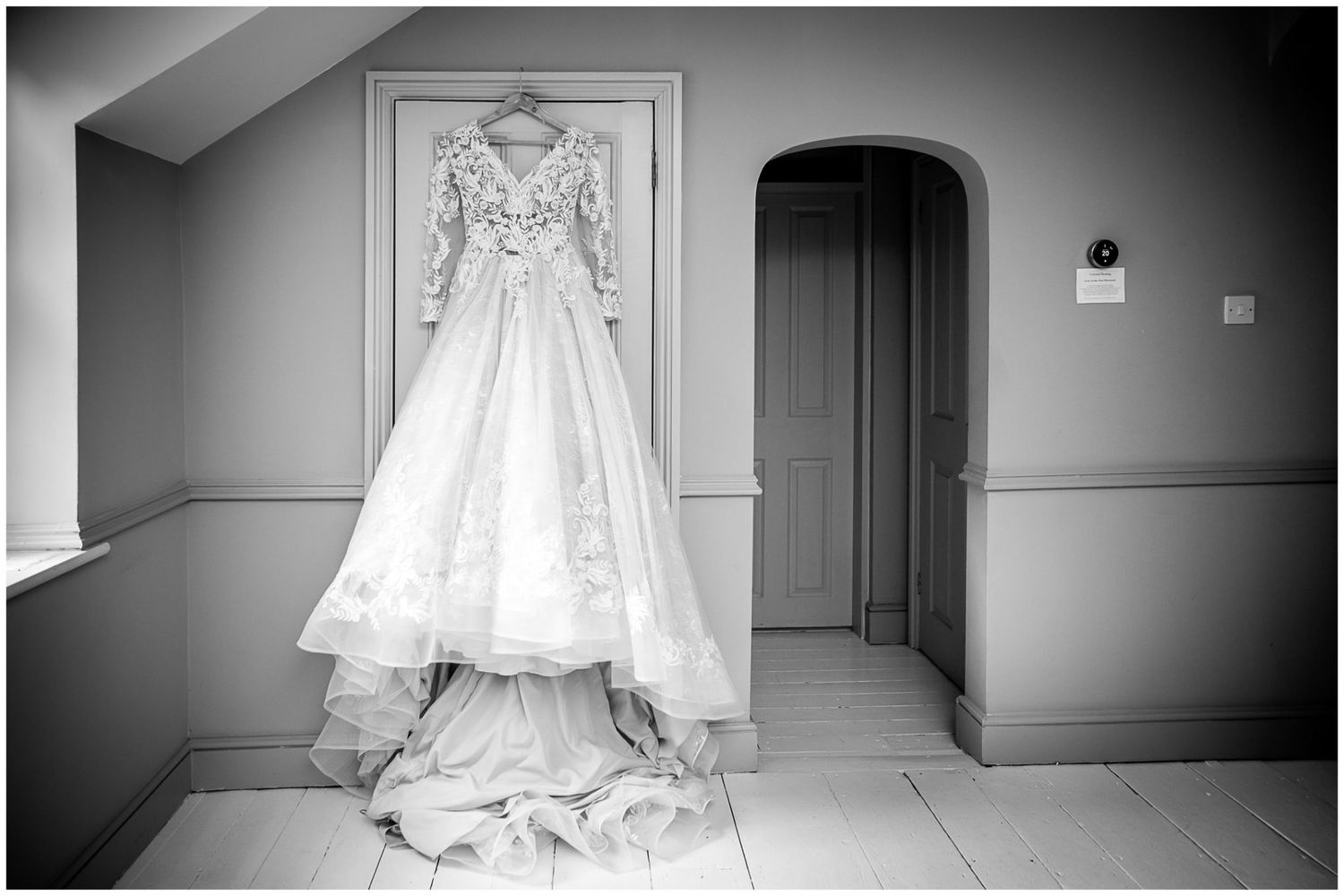 Wedding dress displayed in empty hallway shown from multiple angles in black and white.