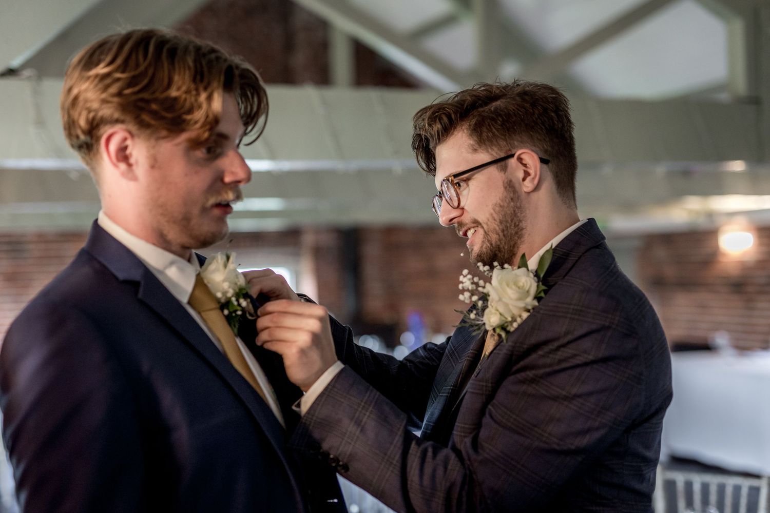 Two people in formal attire share an intimate moment at an indoor venue.