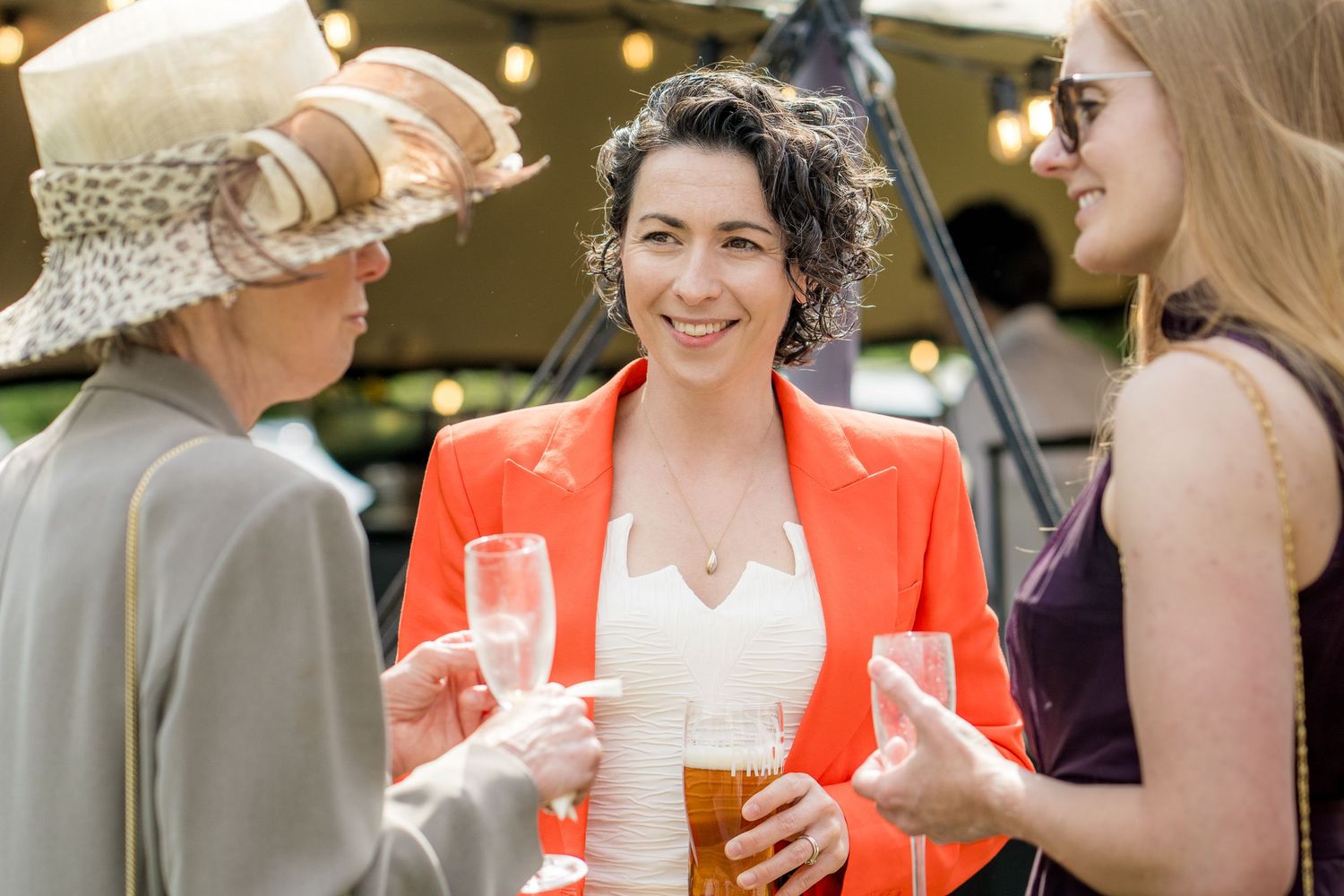 Guests mingling and enjoying drinks during an outdoor wedding celebration.
