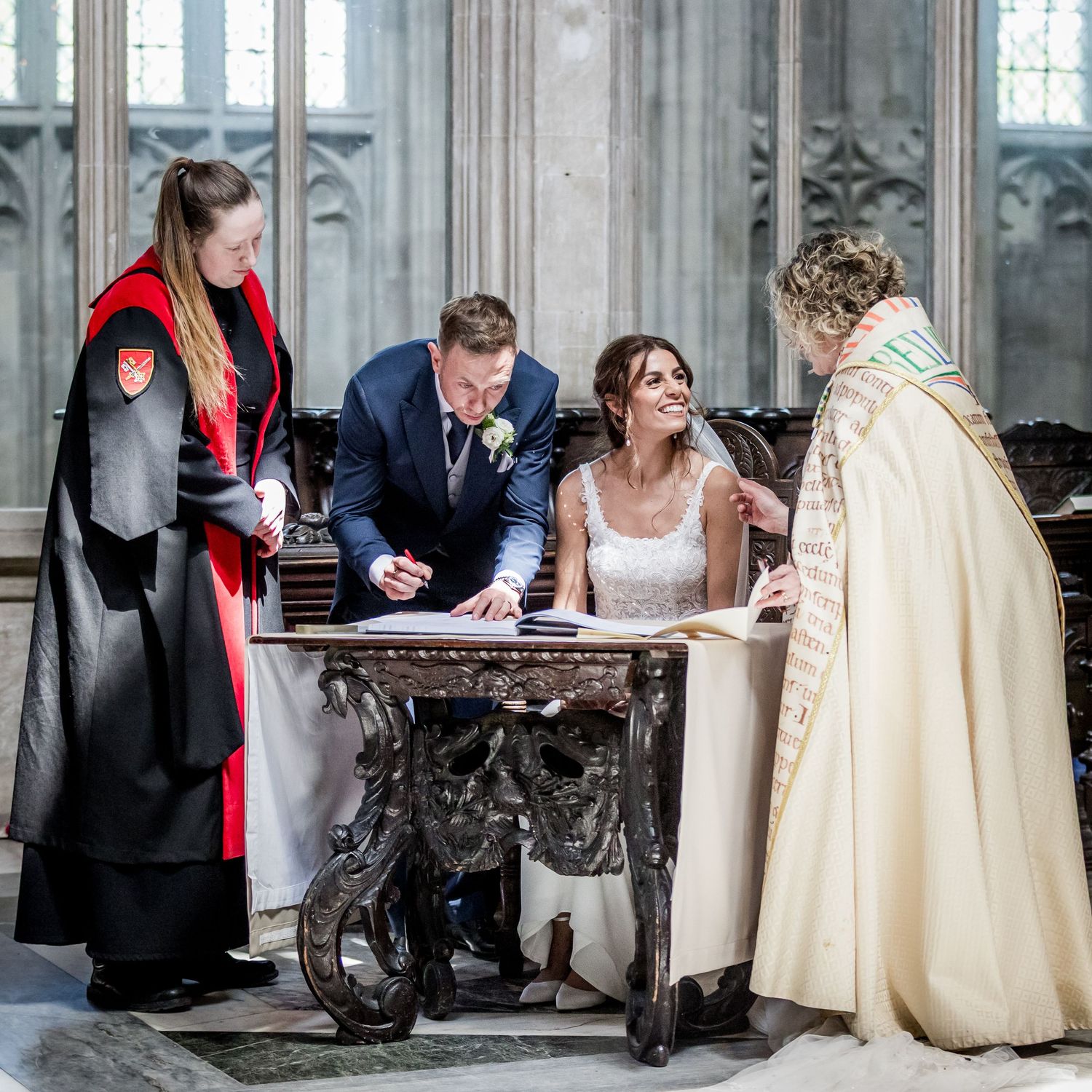 Wedding party gathered in historic cathedral during signing ceremony.