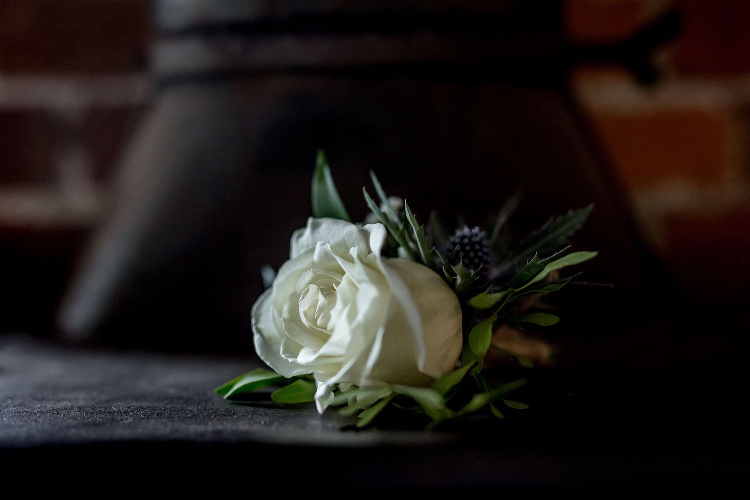 White rose boutonniere detail shot with blurred background.