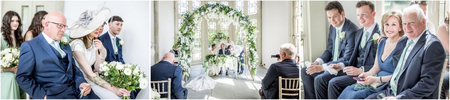Wedding celebration with guests gathered around floral arch decorations.