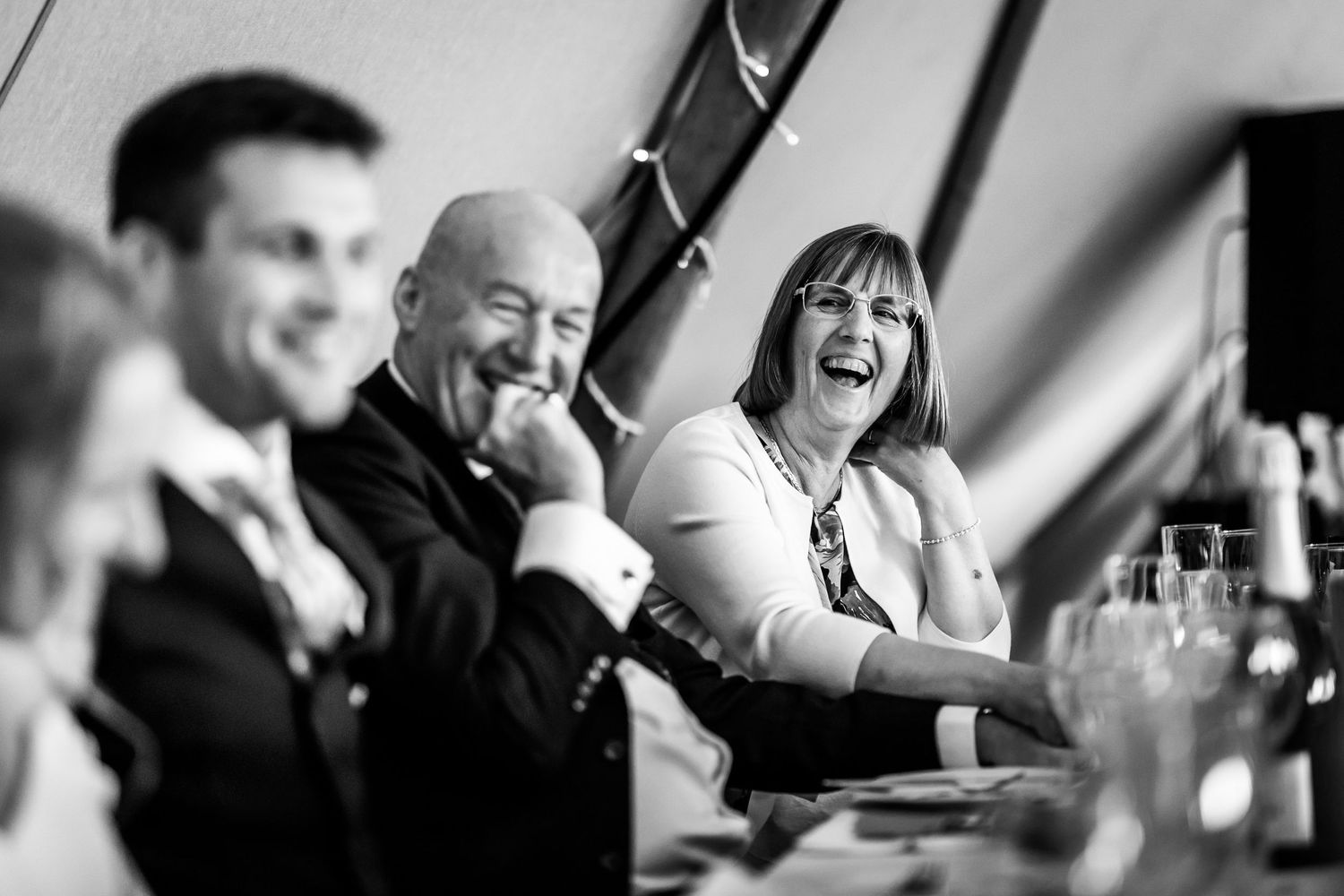 Black and white candid shots of wedding guests during emotional reception moments.