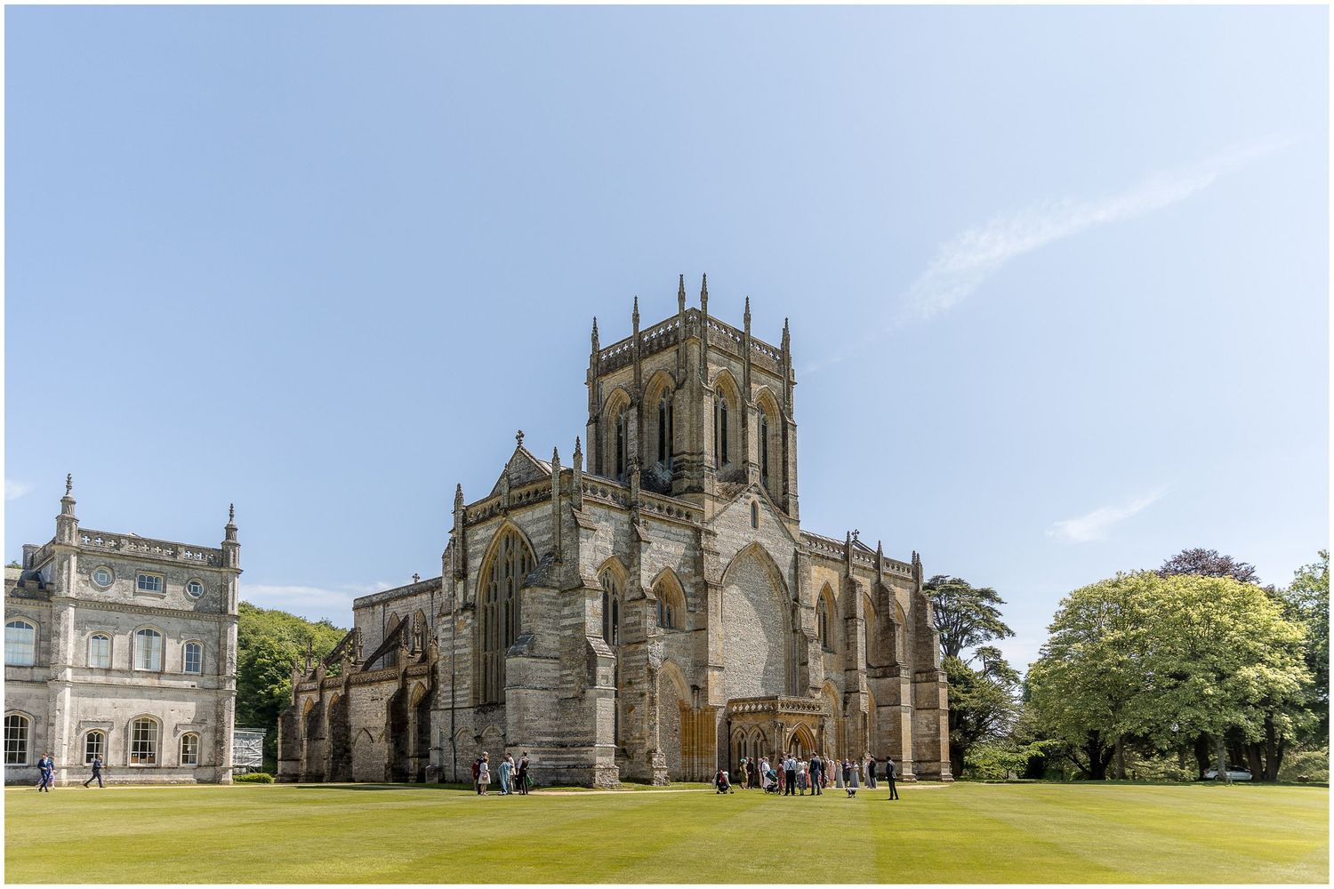 Panoramic view of a historic church and grounds under blue summer sky.