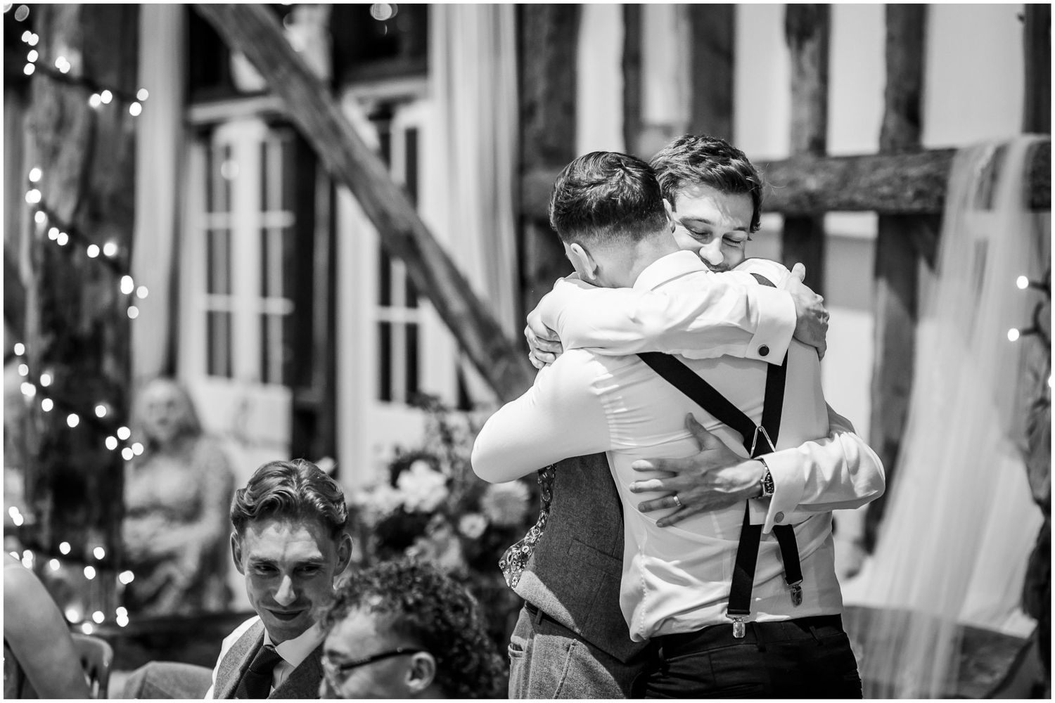 Groom and best man hug after the wedding speeches.