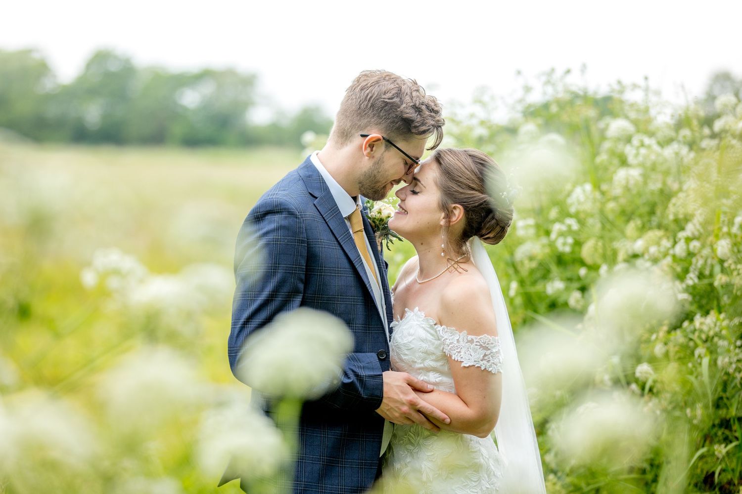 Romantic wedding portrait captured in a dreamy wildflower meadow on a sunny day.