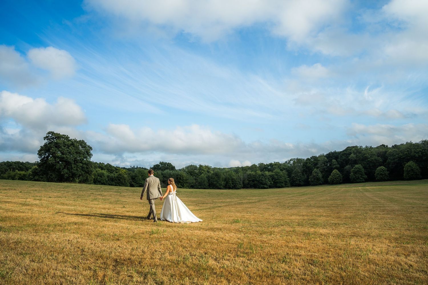 Wedding photography with a bride and groom walking together in the grounds of the Holywell Estate in Hampshire