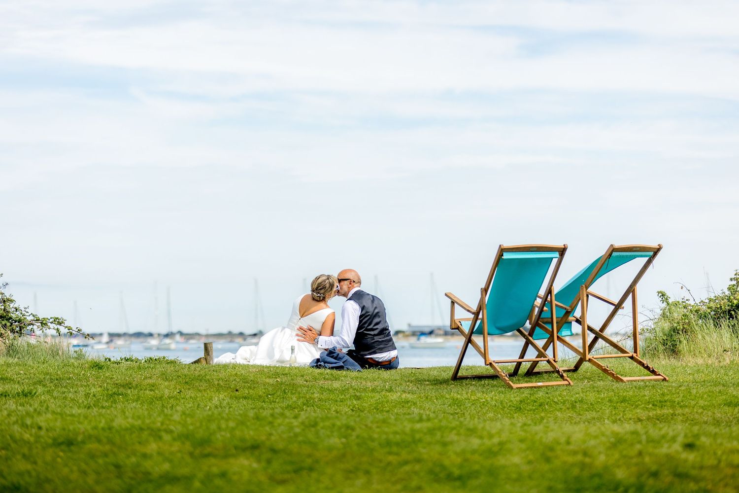 Peaceful landscape with deck chairs overlooking green fields on summer day.
