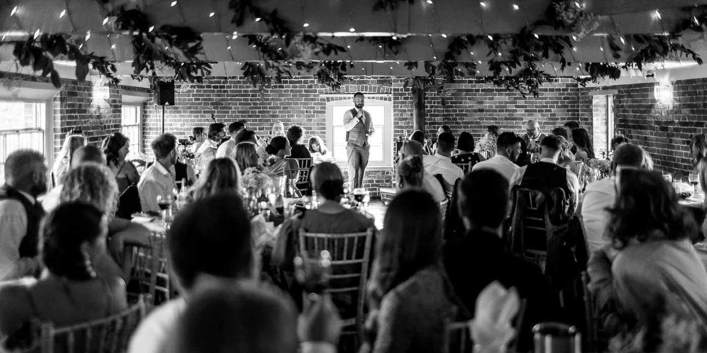 Black and white photograph of a crowded wedding reception dance floor.