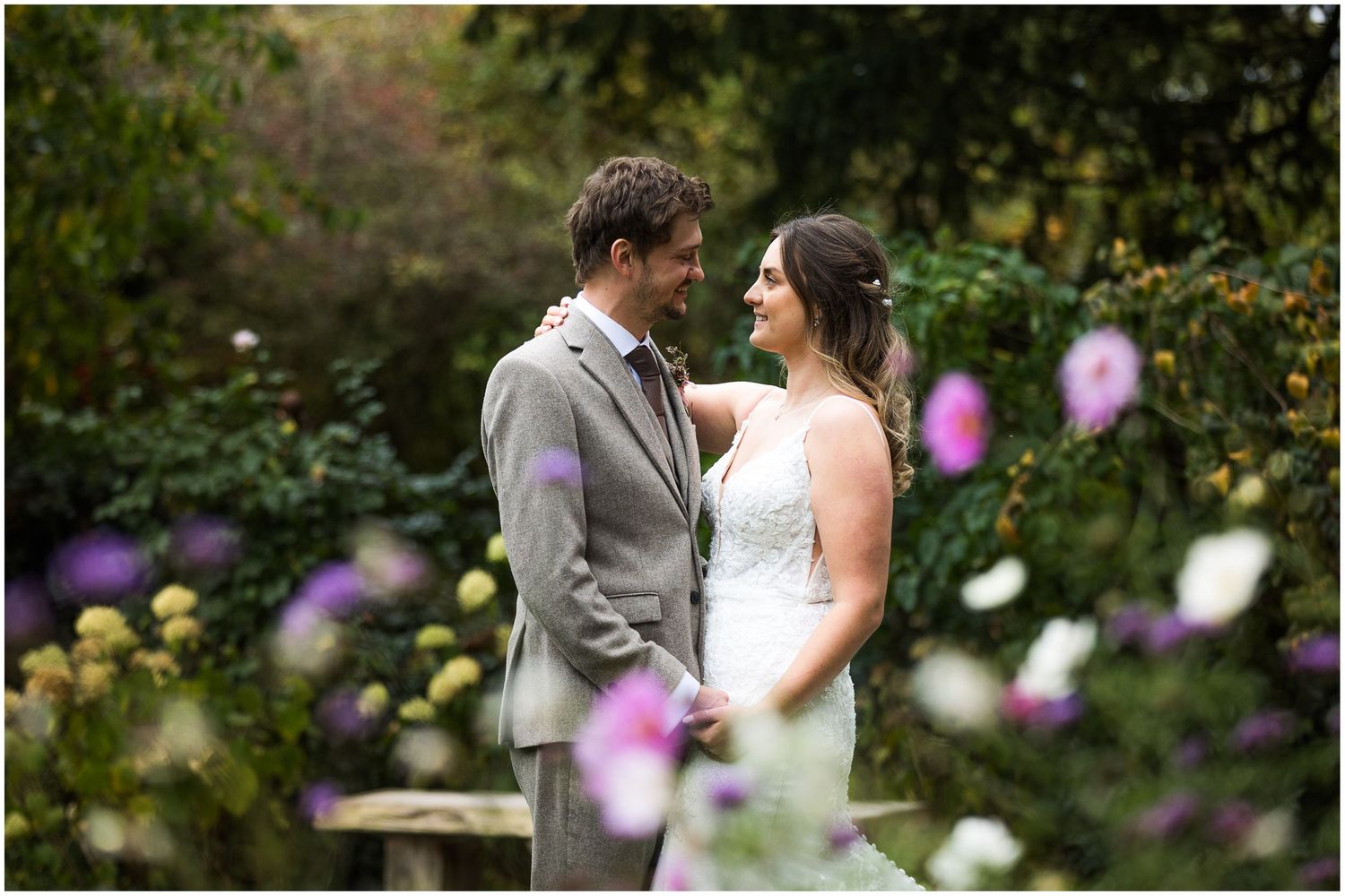 Bride and groom wedding photography at Clock Barn with flowers in foreground