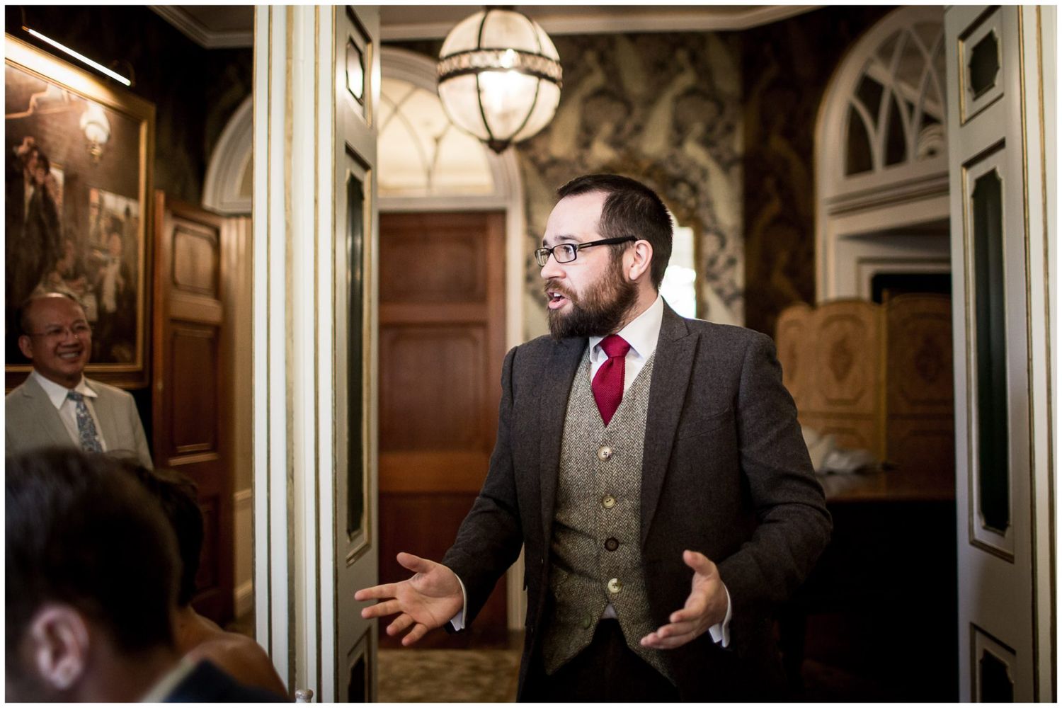 Wedding party gathering in a grand historic building hallway.