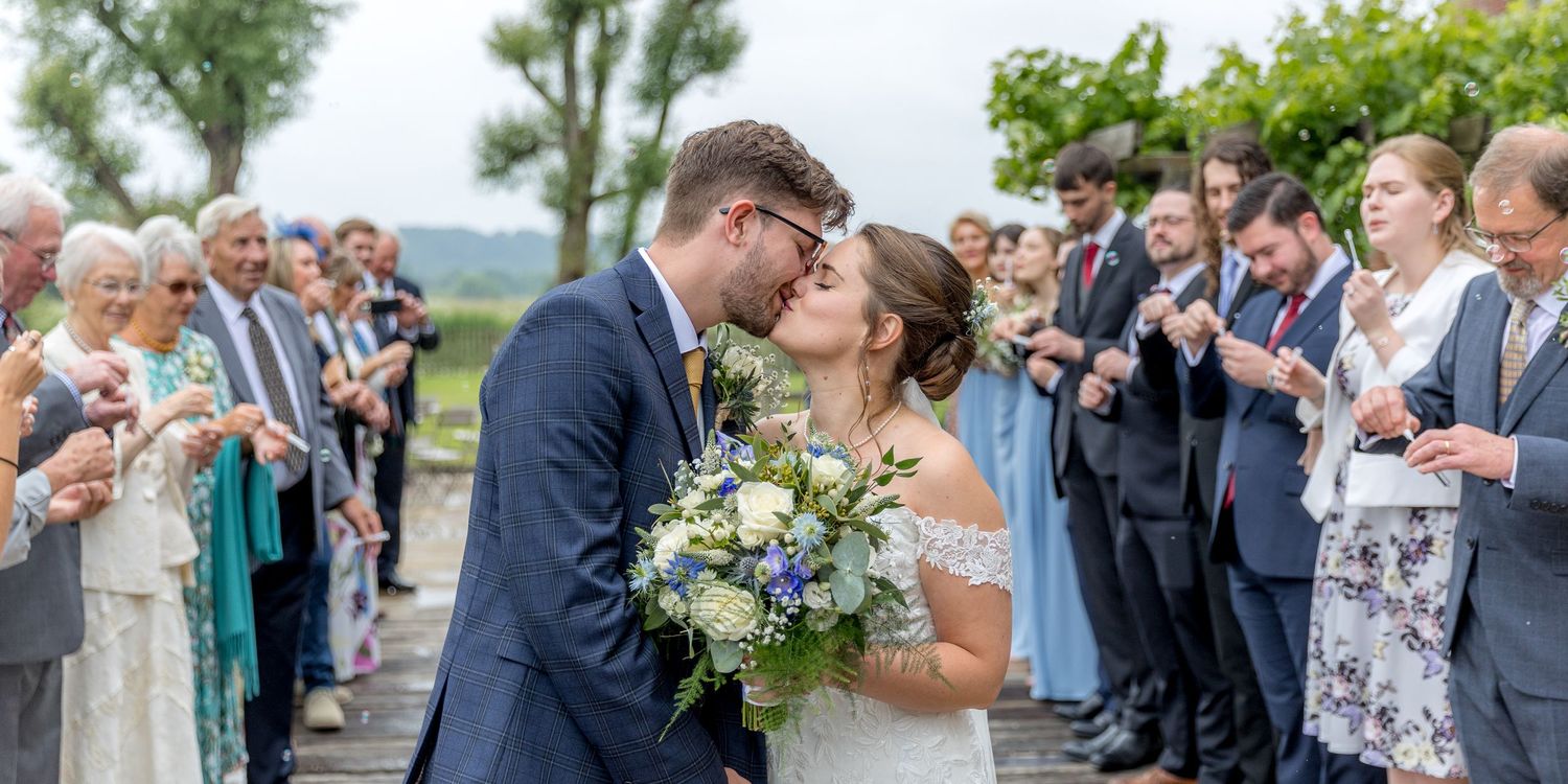 Candid moments captured during an outdoor wedding celebration with guests in formal attire.