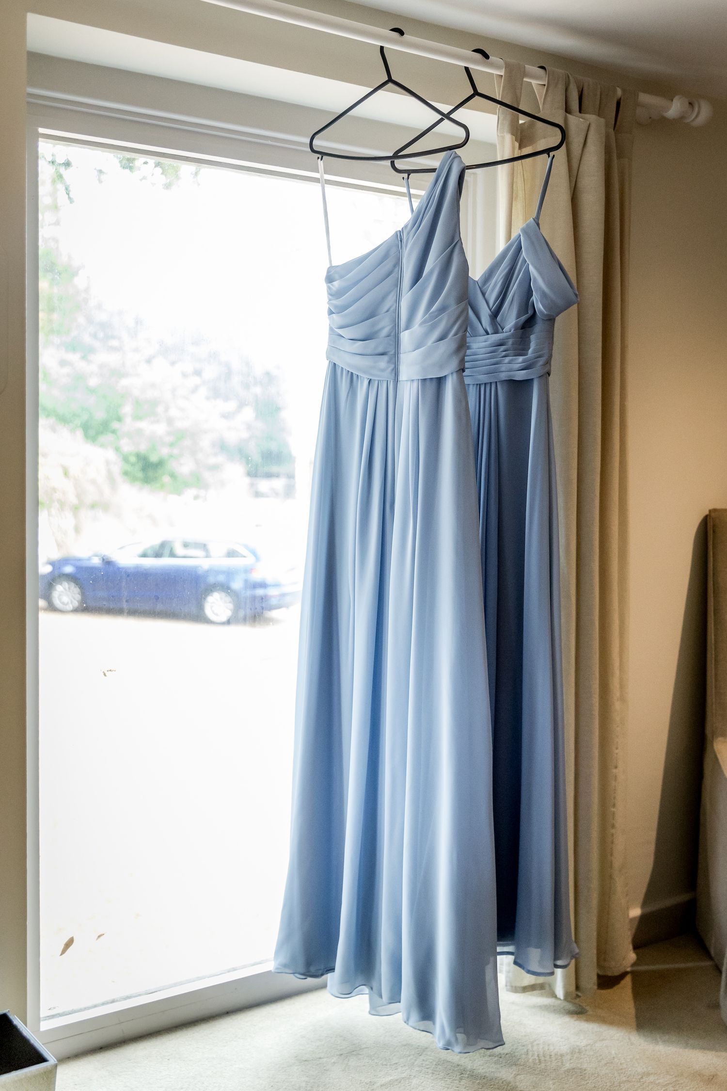Light blue bridesmaid dresses hanging on display in preparation room.