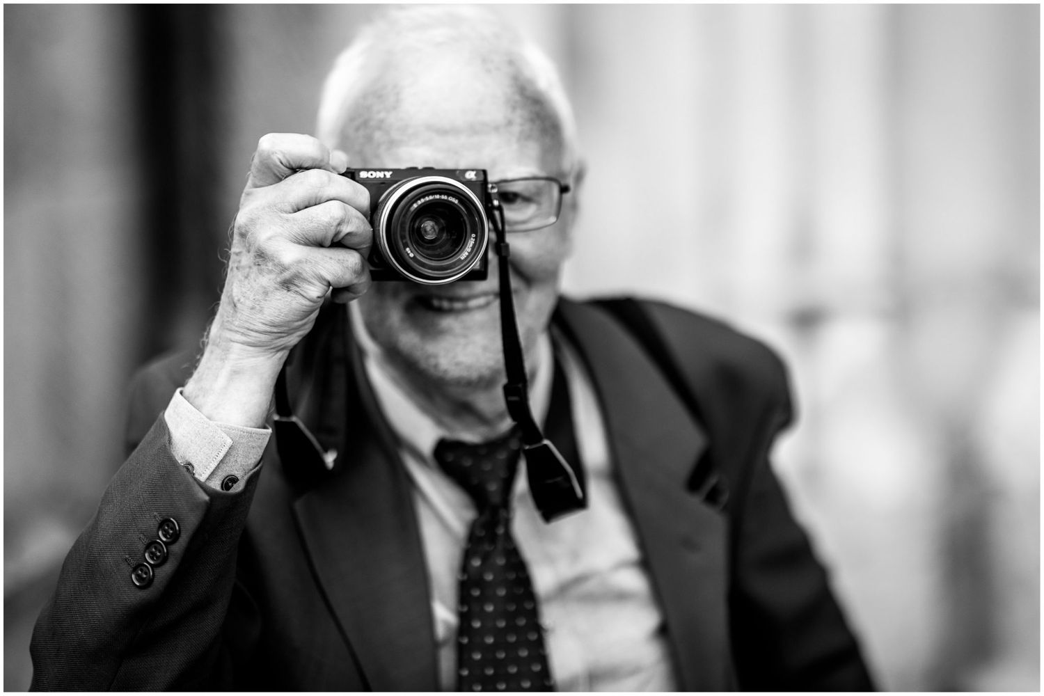 Series of black and white portraits showing a photographer holding different vintage cameras.