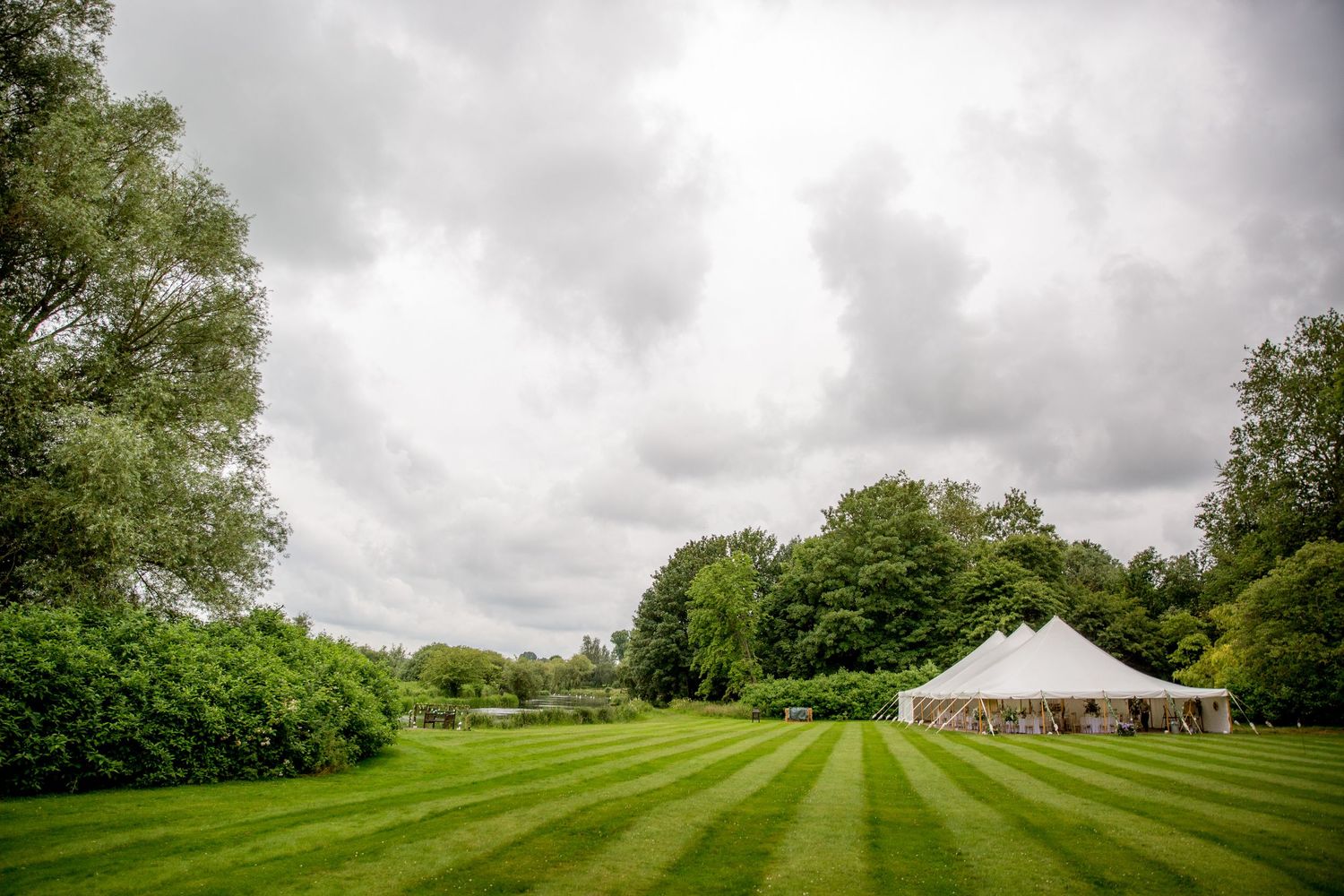 A view of the wedding marquee and riverside lawn at Houghton Lodge