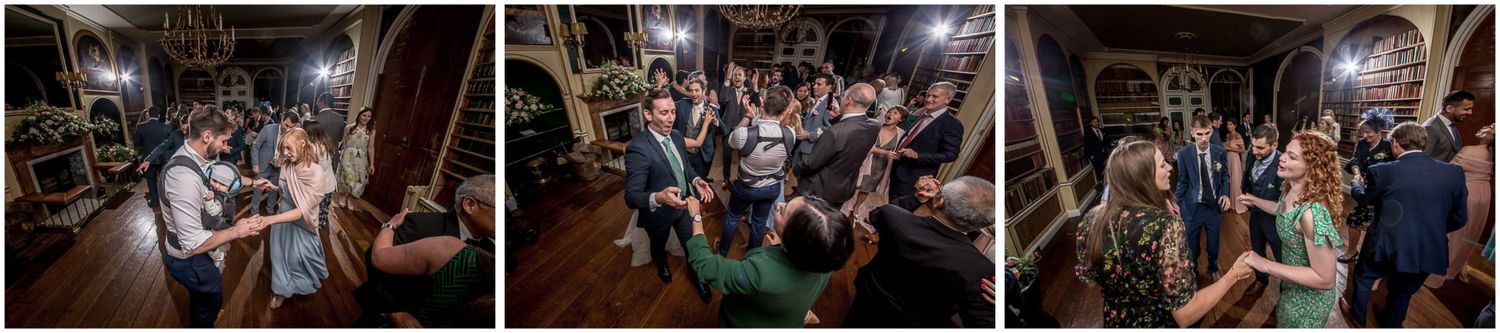 Wedding reception dance party with guests celebrating on a wooden dance floor.