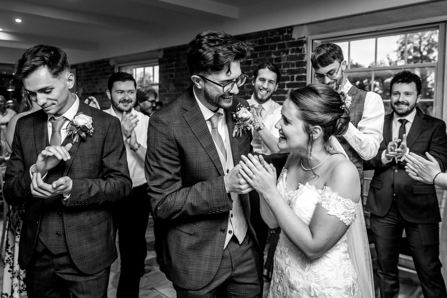 Wedding party members laughing and celebrating during a reception event.