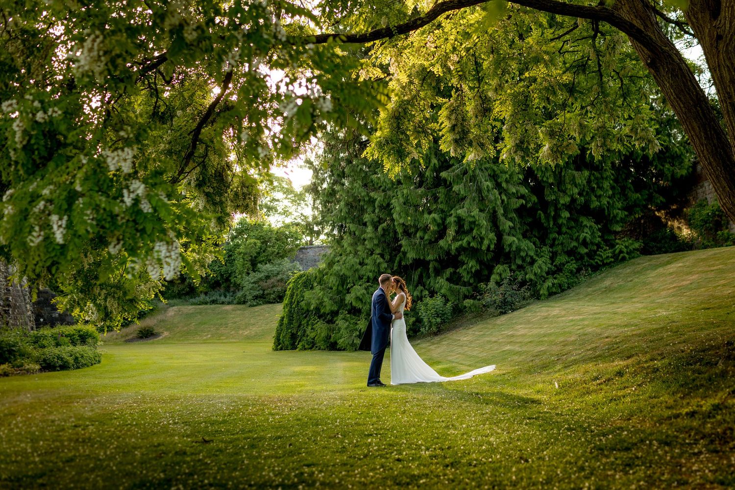 Newlyweds share an intimate moment in a beautiful garden setting during golden hour.
