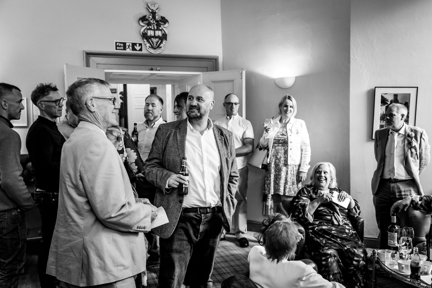 Black and white photos showing guests mingling and socializing at an elegant indoor reception.