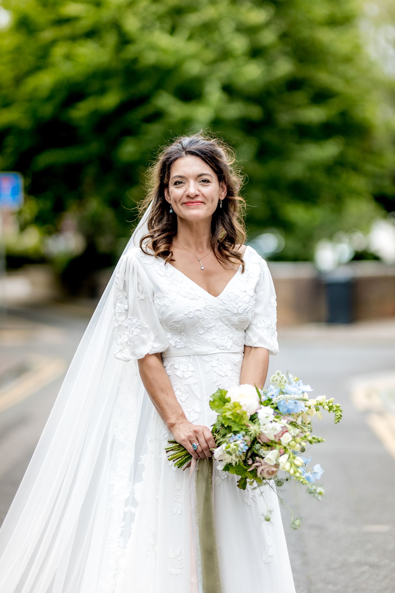 Beautiful bridal portraits on a street with flowing white dress and bouquet.