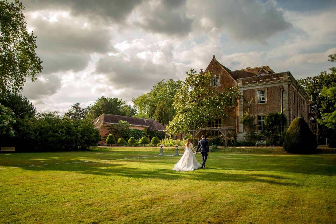 Wedding venue landscape with dramatic cloudy sky and historic buildings.
