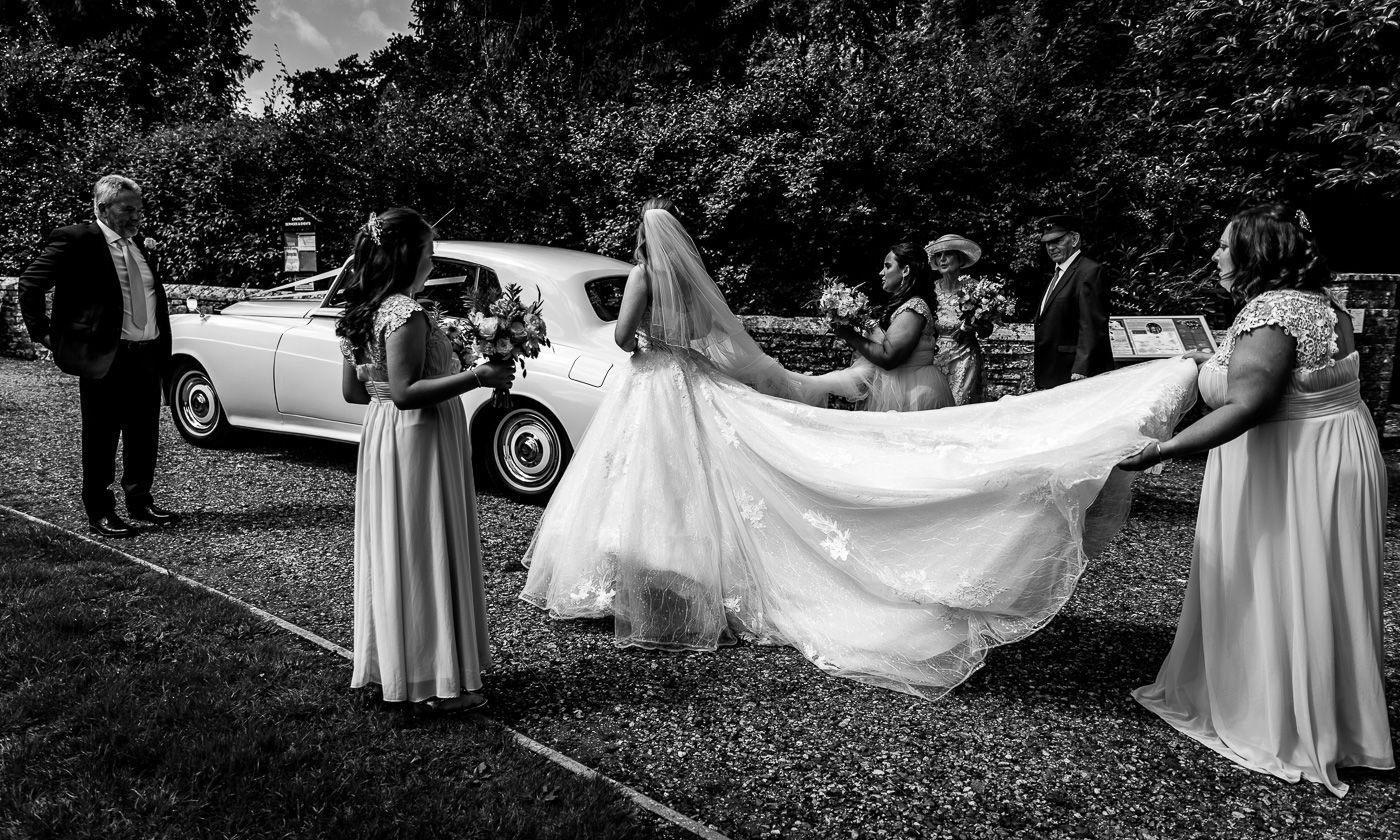 Black and white wedding photography sequence showing dress details outdoors.