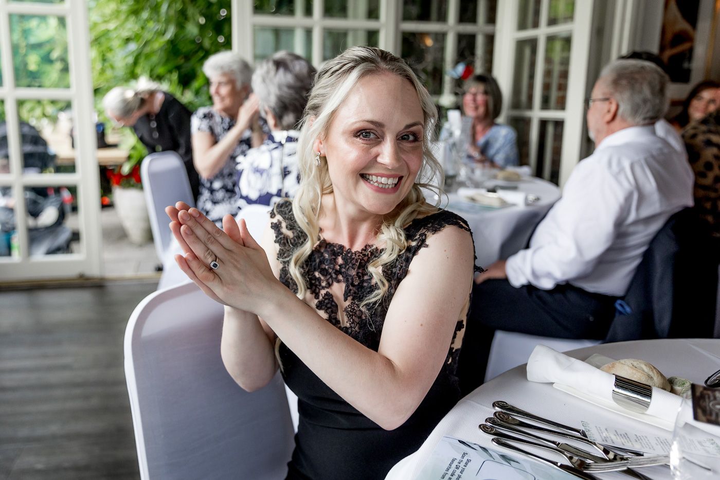 Guest enjoying reception dinner on outdoor patio with table settings.