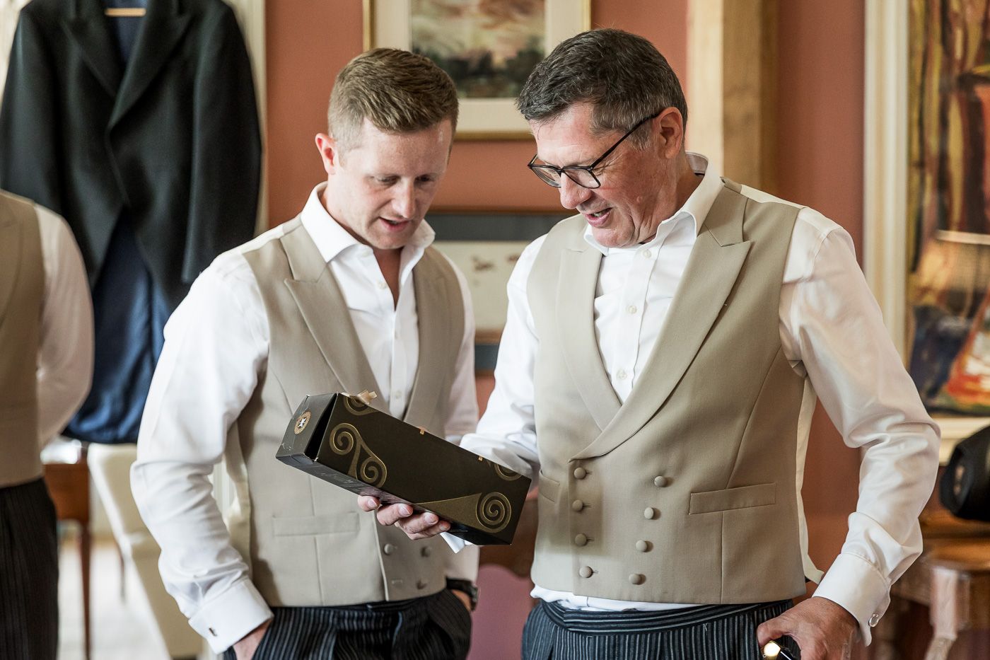 Two people in formal attire getting ready before a wedding ceremony.