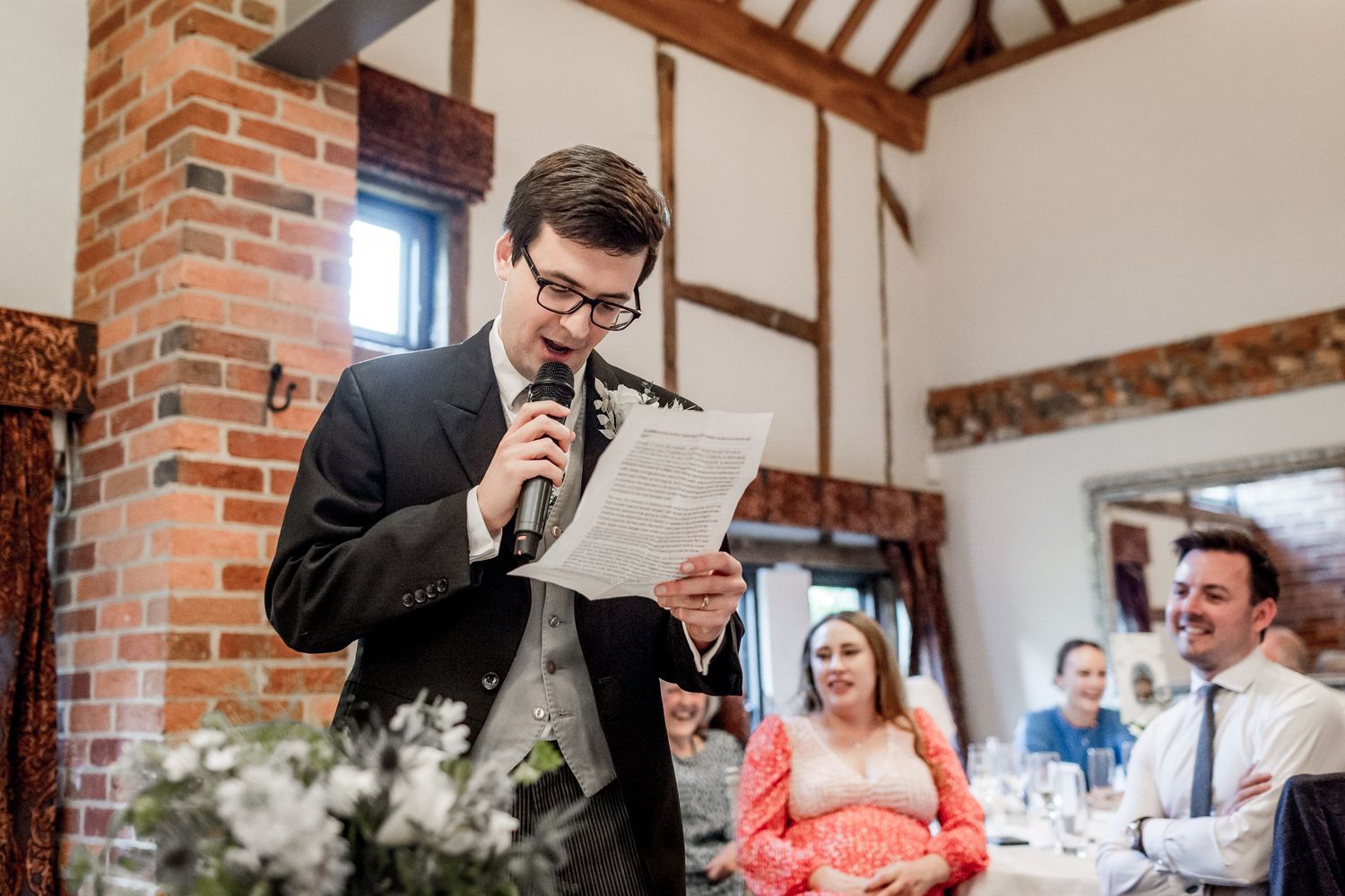 Wedding speeches and celebrations inside a rustic brick and timber venue.