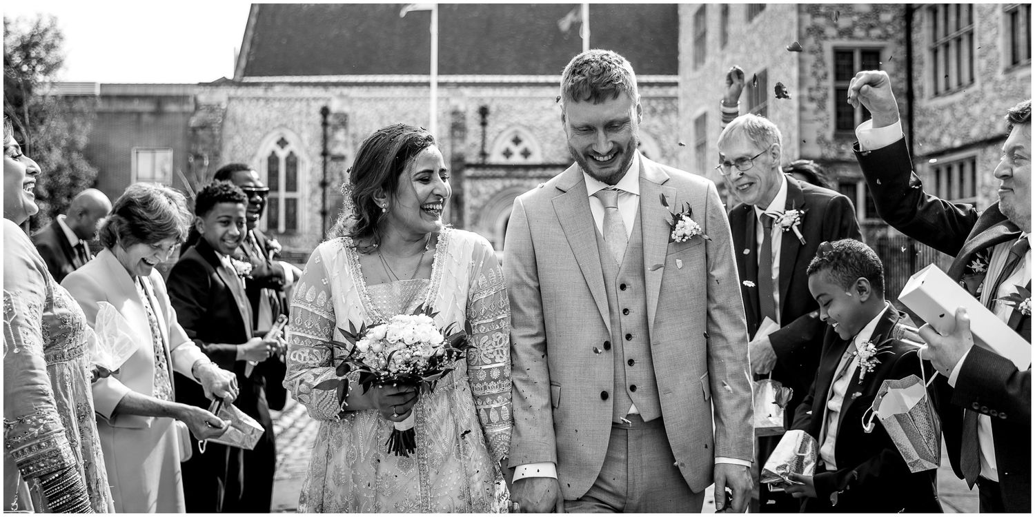 Wedding party celebrating outside a historic stone building.