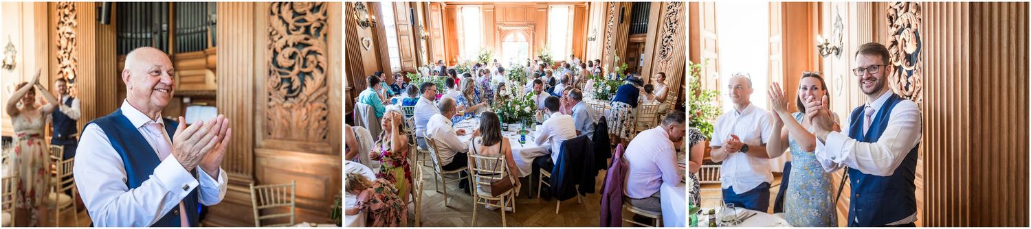 Wedding guests stand to greet the bride and groom as they enter the room for the start of the wedding breakfast and celebrations