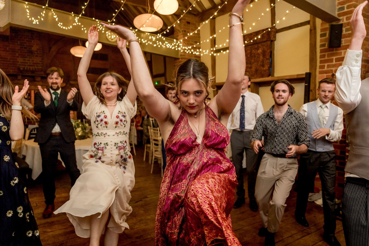 Wedding reception dance party with string lights creating a festive atmosphere.