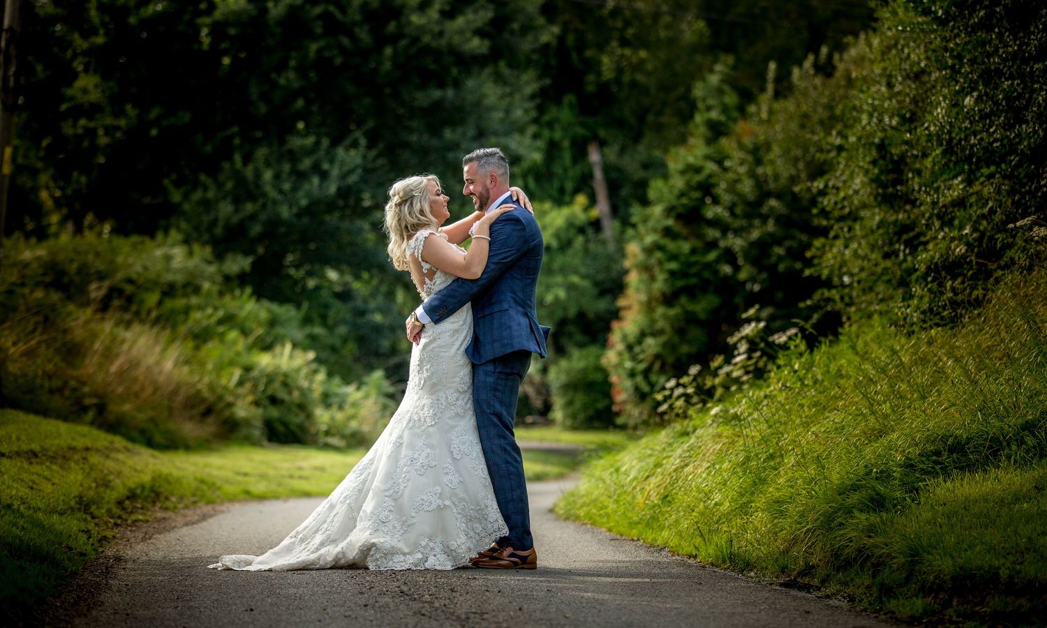 Bride and groom posed for wedding photography on a country lane outside Southdowns Manor, Petersfield wedding venue