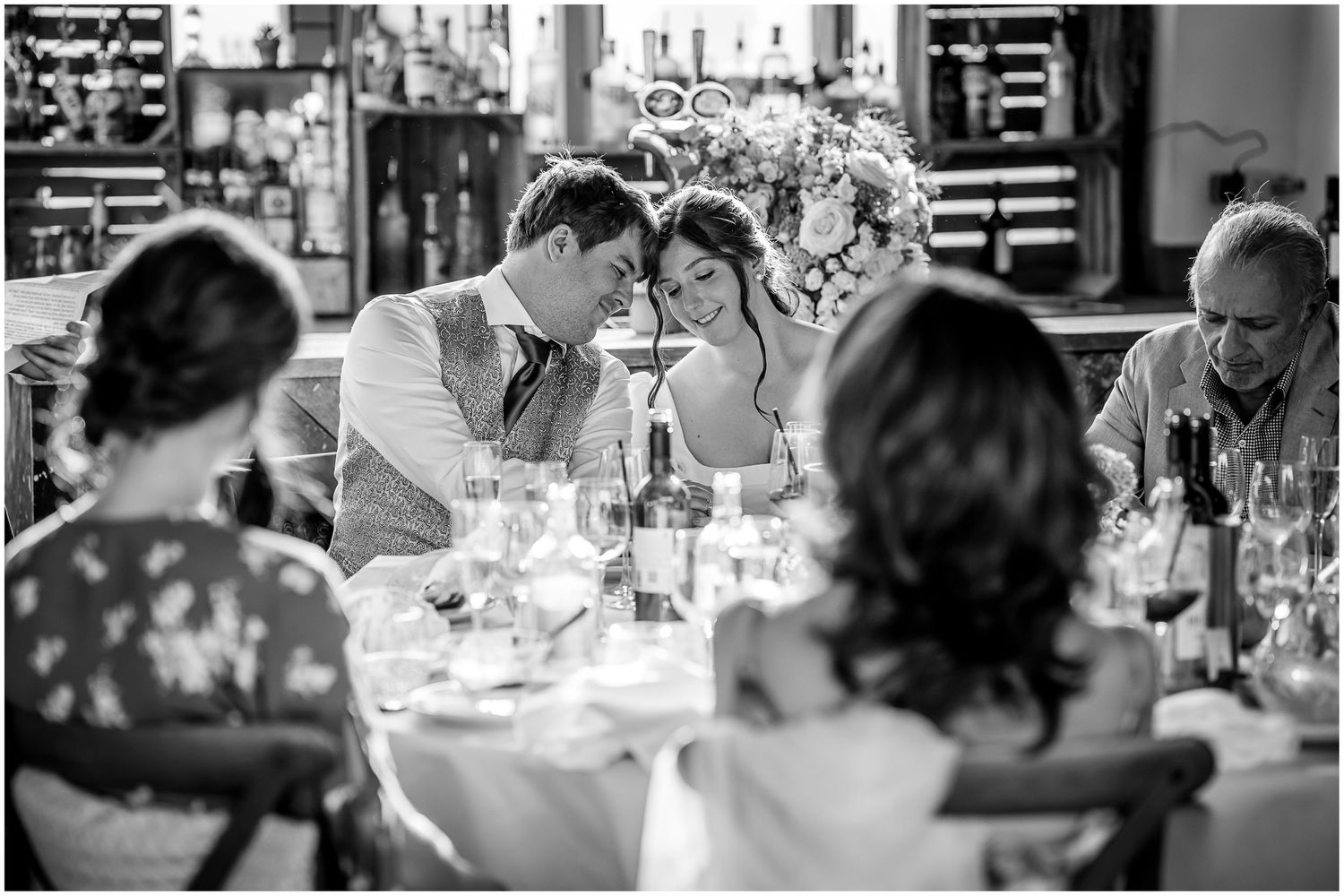 Wedding guests seated at tables during an indoor reception celebration.