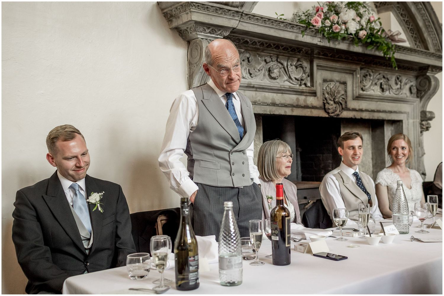 Wedding reception dining tables set up in grand historic venue with classic decor.