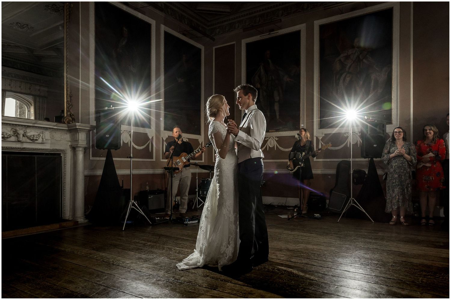 Dramatic evening dance in an elegant historic room with chandelier lighting.