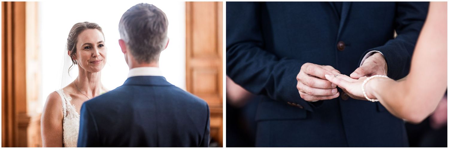 A bride smiles at her groom during wedding ring exchange ceremony in elegant indoor venue.