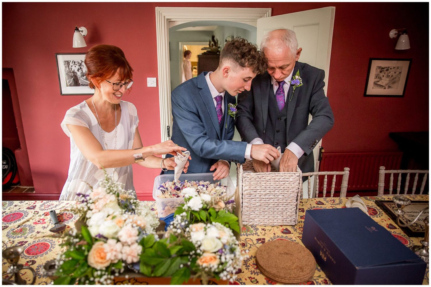 People signing documents and looking at paperwork together at a table with white floral centerpieces.