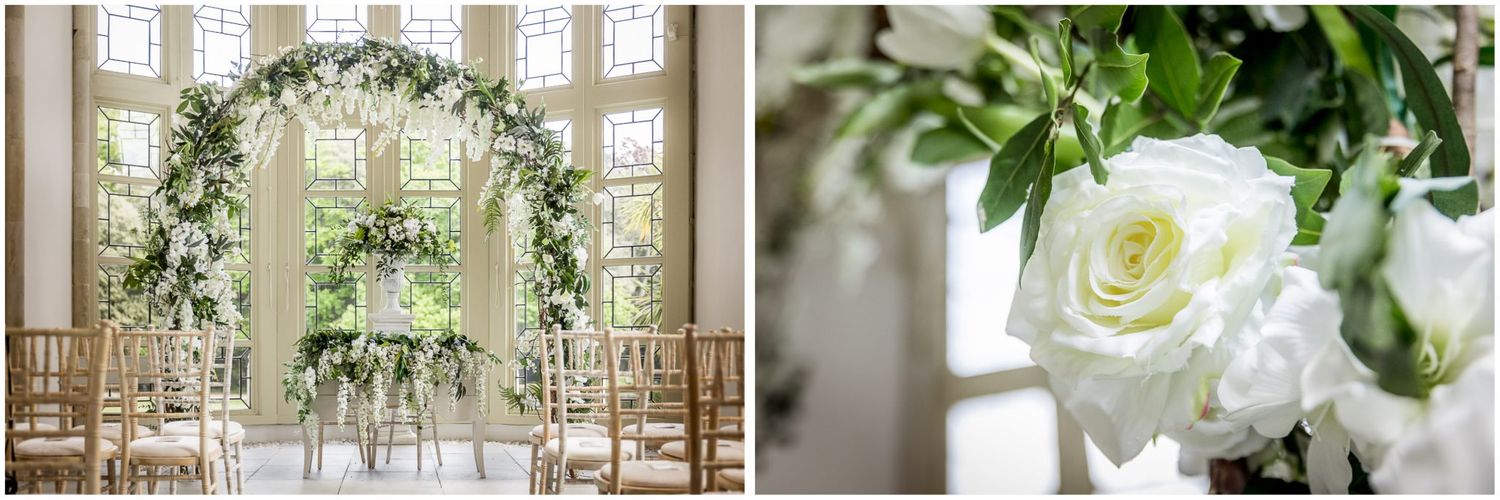 Elegant wedding venue interior with white floral arrangements and natural light streaming through windows.