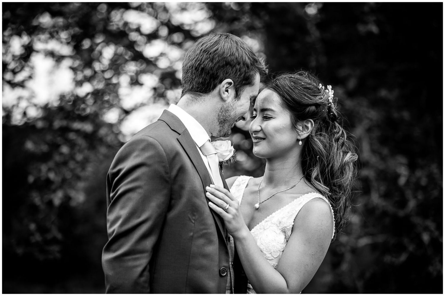 Intimate black and white portrait of newlyweds sharing tender moment.