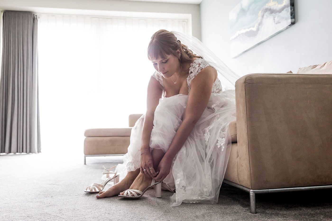 Elegant bridal preparation moments captured in a bright, modern room setting.