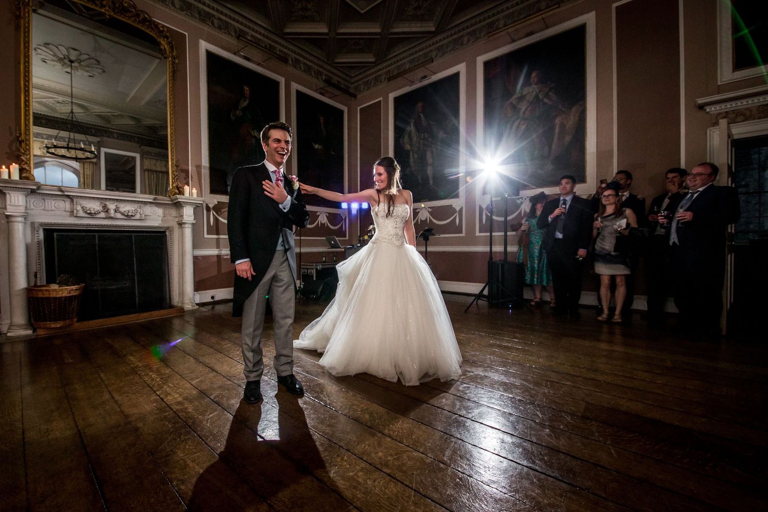Couple dancing together on a wooden floor during their wedding reception.