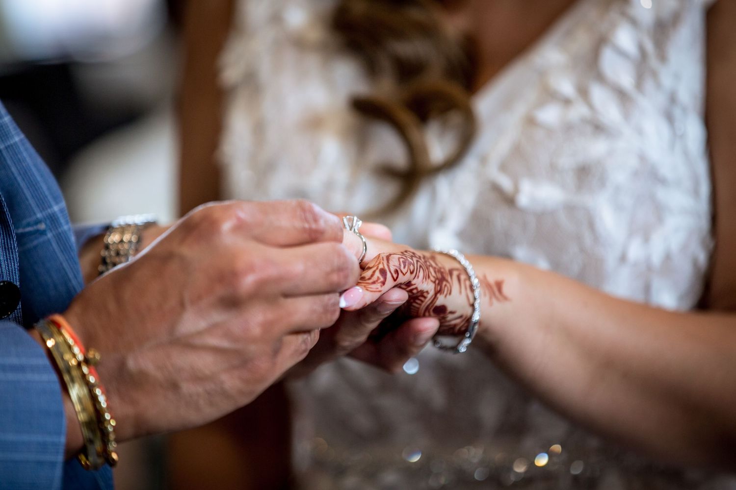 Close-up view of hands exchanging wedding rings during a romantic ceremony.