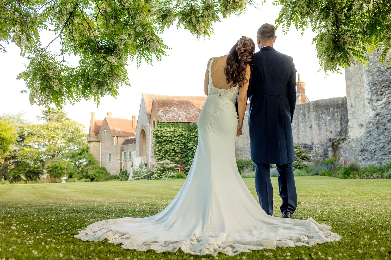 Wedding photography session on manicured grounds with historic building in background.