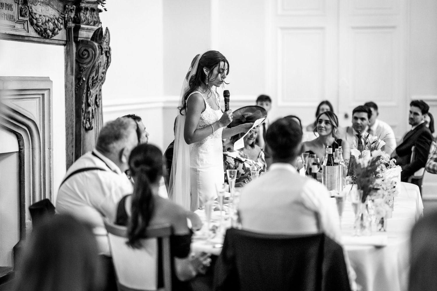 Black and white photo capturing candid moments during a wedding reception.